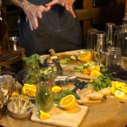 Mixologist showing off a table full of cocktail fresh ingredients such as lemons and more